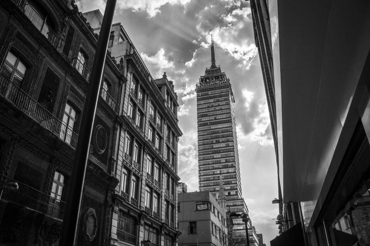 Black and white photo of Torre Latinoamericana in Mexico City. Urban street perspective.